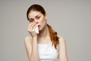 congested woman wiping her nose